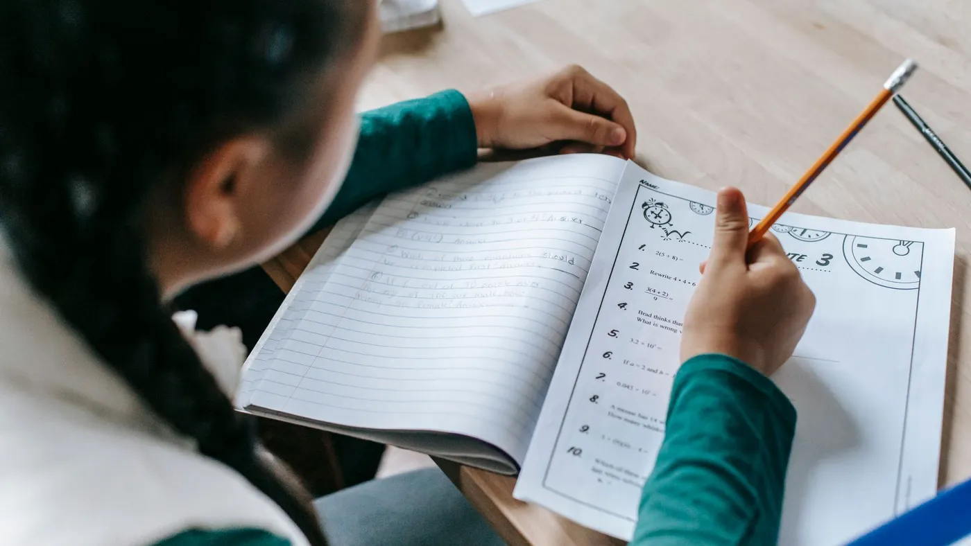 Yukarıdan görülen, üzerinde defter ve kalemler olan bir çalışma masası