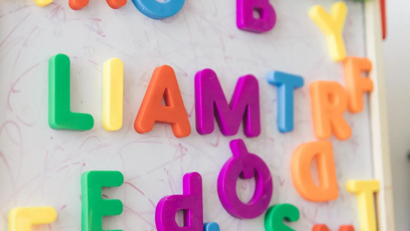 Colorful magnetic letters arranged on a whiteboard